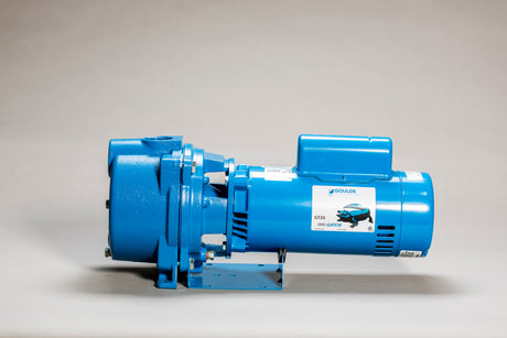 A blue industrial pump with labels and a mounting bracket, shown against a plain background.