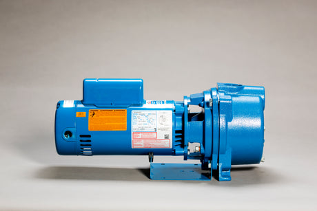 A blue GT20 Series industrial motor by GOULDS, equipped with a corrosion-resistant impeller and various labels and warnings, rests on a light grey surface against a neutral background. The cylindrical motor body is expertly mounted on a flat base, ensuring durability and reliability in diverse applications.